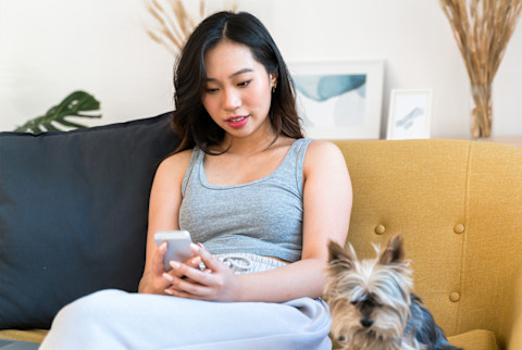Woman using a phone on the couch.