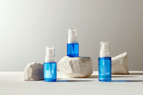 Skincare cosmetics bottles on gray concrete block Skincare cosmetics bottles on gray concrete block