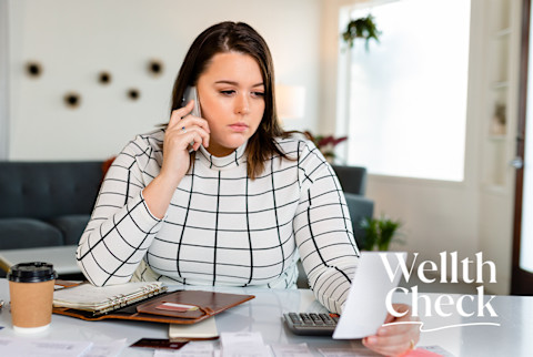 Woman on the phone looking at a bill wearing a black and white checkered turtleneck Woman on the phone looking at a bill wearing a black and white checkered turtleneck