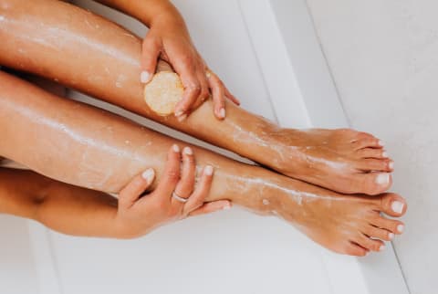 Woman scrubbing her legs