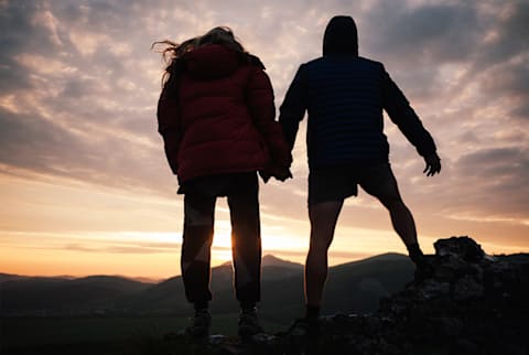 friends holding hands looking at sunset friends holding hands looking at sunset