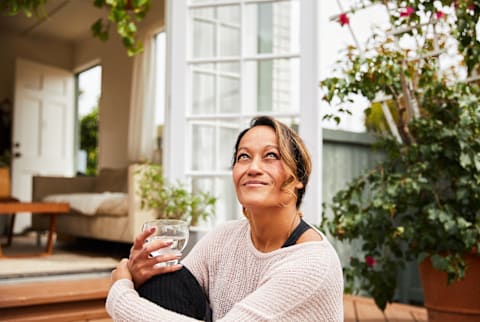 Smiling mature woman relaxing on her patio at home Smiling mature woman relaxing on her patio at home