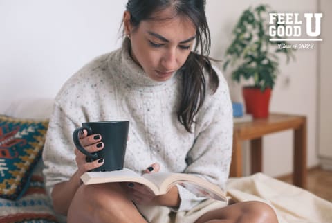 cozy woman reading book with cup of tea tea in hand