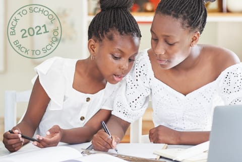 Mom & daughter sit together in the living room at home and do home work