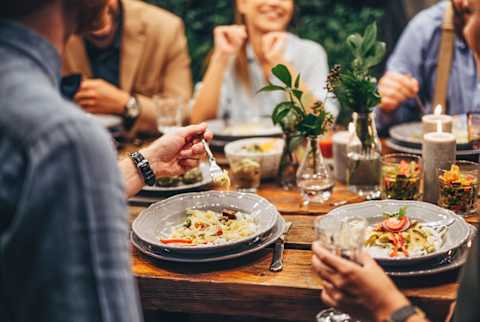 Group of people eating and chatting at outdoors dinner party. Group of people eating and chatting at outdoors dinner party.