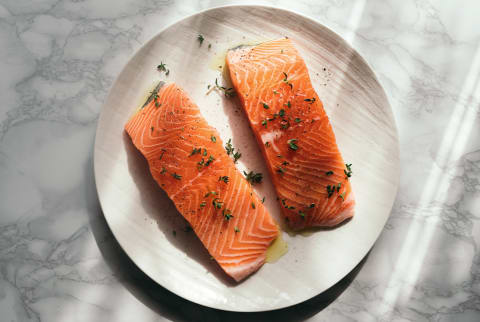 two raw salmon steaks on plate