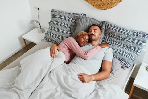 Young Couple Asleep In Bed