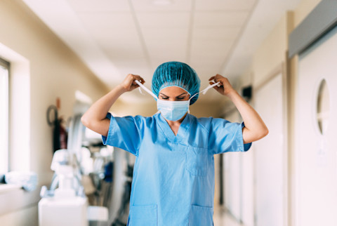 Nurse Putting on a Medical Mask in a Hospital