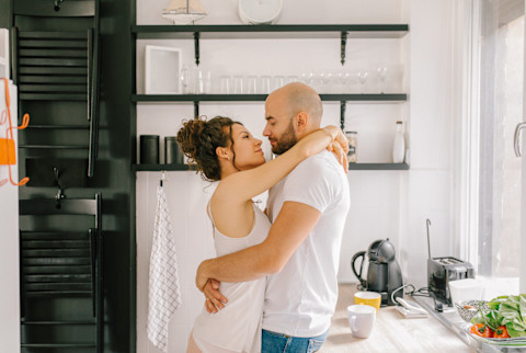 Young couple embracing in the kitchen Young couple embracing in the kitchen