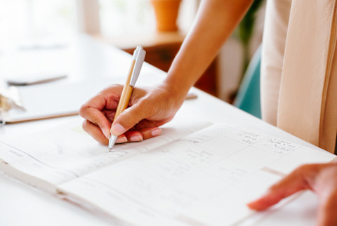 Unrecognizable Woman Writing Something Down in A Planner Unrecognizable Woman Writing Something Down in A Planner