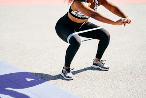 Woman Doing Squats Outdoors with a Resistance Band Woman Doing Squats Outdoors with a Resistance Band