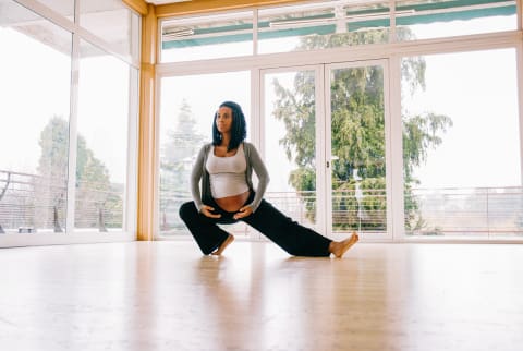 Pregnant Woman in Her Third Trimester Stretching in a Fitness Studio