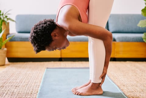 Woman Doing Yoga in Her Living Room, Forward Fold