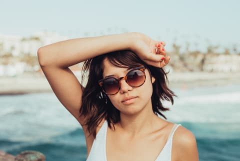 Young Woman At The Beach Wearing Sunglasses