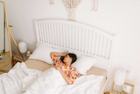 Young Woman Asleep in Bed on Sunny Morning