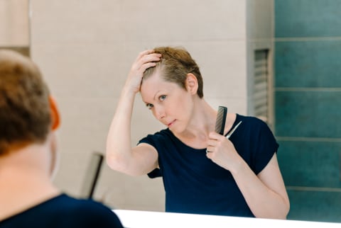 A Woman Gives Herself A Haircut At Home