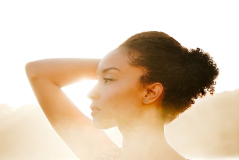 Closeup portrait of a beautiful young woman at the beach at sunset