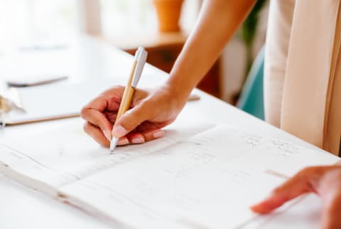 Unrecognizable Woman Writing Something Down in A Planner