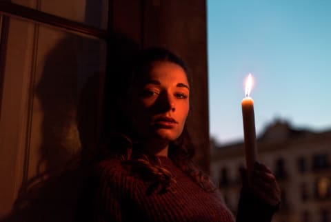 Portrait of a woman holding a candle light during sunset hour