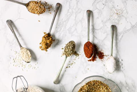 Herbs And Spices On Spoons On A Marble Background.