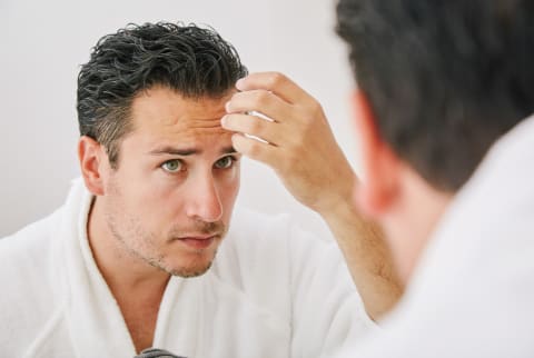 Man Checking His Hair in the Mirror