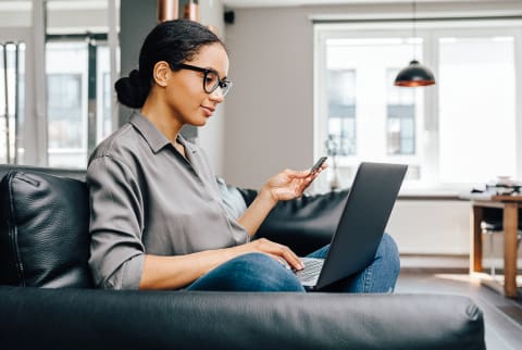 Woman Using a Credit Card and Her Laptop At Home