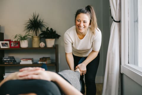 Young Woman Chiropractor Giving Treatment