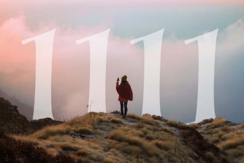 woman standing on scenic overlook with numbers 1111 in the distance