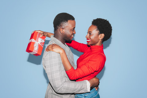 Portrait of a couple hugging and holding a present