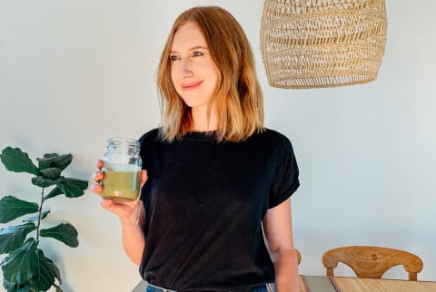 mindbodygreen Editor, Kristine Thomason holding a healthy green smoothie