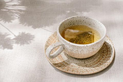 A cup of fresh tea at a picnic outside with reflections of nature A cup of fresh tea at a picnic outside with reflections of nature