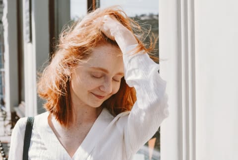 Redhead ruffling her hair