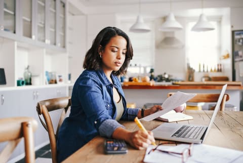 Woman Reviewing Her Finances At the Kitchen Table