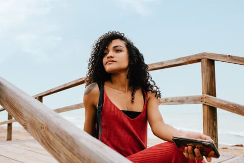 Inspired Young Woman Sitting on a Beach