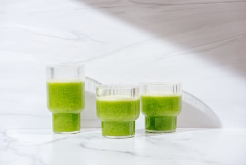 Green smoothies on a marble background