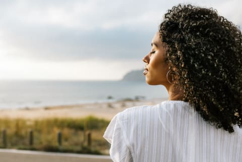 (Last Used: 2/25/21) Young Woman Facing The Ocean with Her Eyes Closed