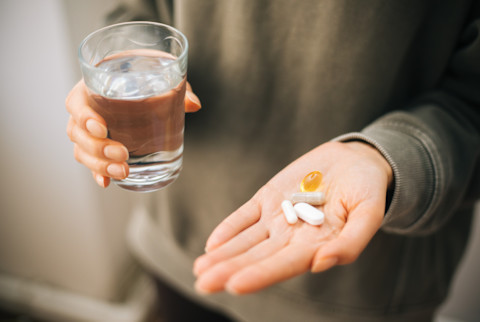 A hand holding a bunch of pills in an open palm stock photo...