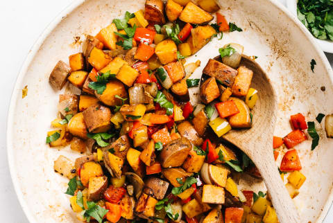 A nutrient packed breakfast side dish with sweet potatoes, onions, red and yellow bell peppers and Italian parsley