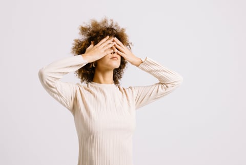 Stressed Woman with Hands Over Her Eyes in a Studio
