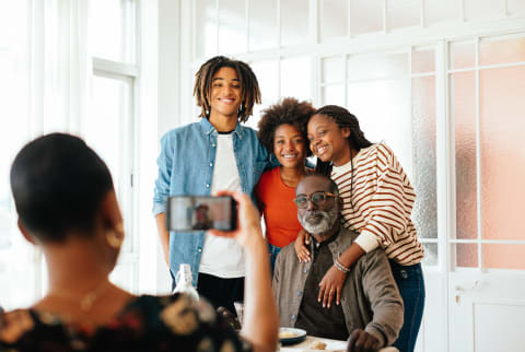 Family Gathered Around Dining Table Taking a Photo Together