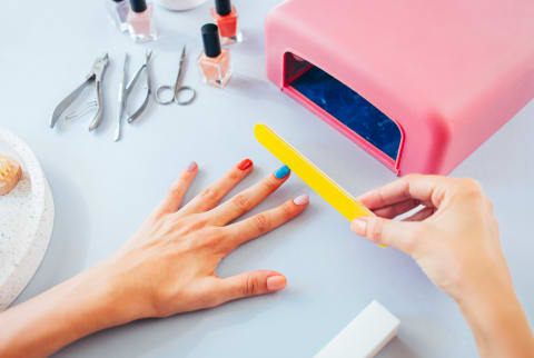 Woman Manicuring Her Nails in Multiple Colors