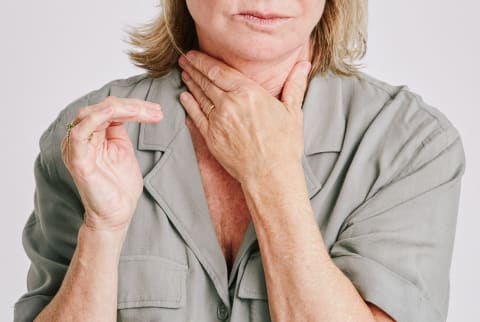 Woman With Her Hand on Her Throat Struggling with Shortness of Breath