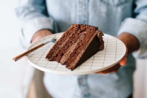 Man Holding a Plate with a Slice of Chocolate Cake