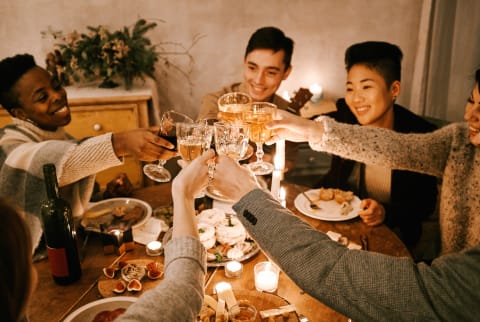 Small Group of Friends Gathered Around a Dining Table Cheersing