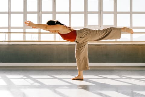 Woman Practicing Yoga in a Sunny Studio - Warrior Three Pose
