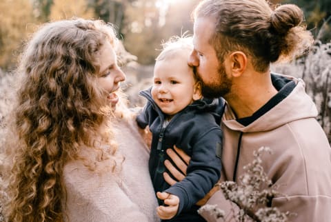 Mother and Father Holding Their Young Son on an Outdoor Walk