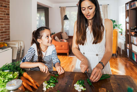 mother and daughter cutting vegetables