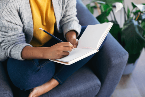 Woman Writing in Her Journal on the Couch