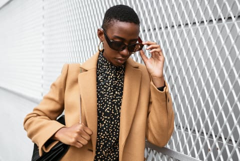 woman looking down holding sunglasses