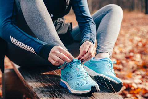 Woman Tying Running Shoes on an Outdoor Run Woman Tying Running Shoes on an Outdoor Run